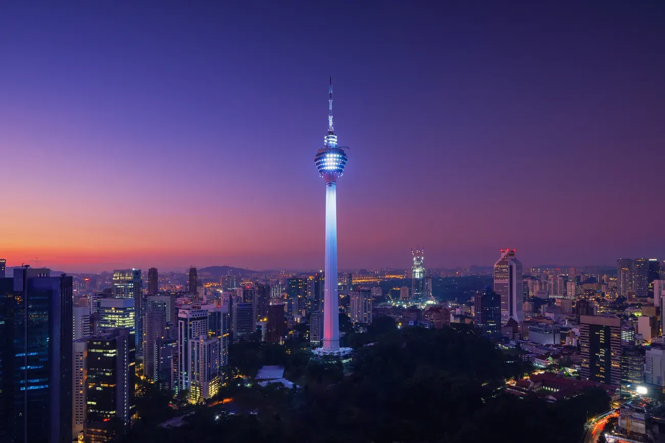 The Menara Kuala Lumpur tower lit up over downtown Kuala Lumpur at night