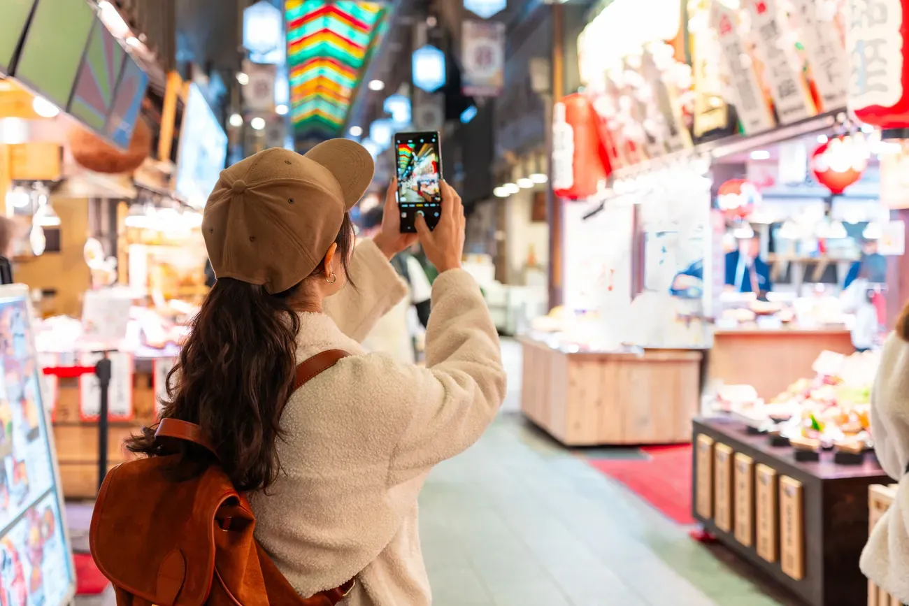 Shoppers browsing the stalls of the popular Nishiki Market in Kyoto