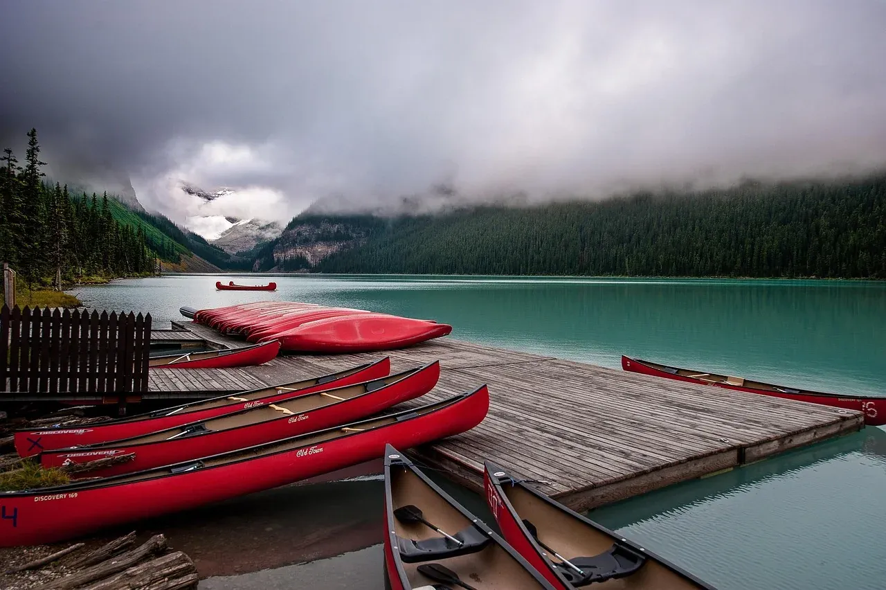 Red canoes stacked at the boathouse on the shore of Lake Louise