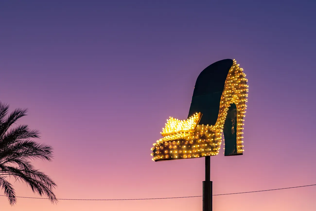 A giant illuminated neon shoe at the Neon Museum in Las Vegas at sunset