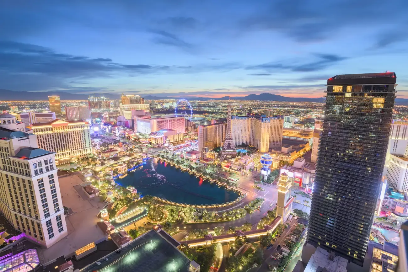 Aerial view of the Las Vegas Strip at dusk with the Bellagio fountain lake and the High Roller wheel in the distance
