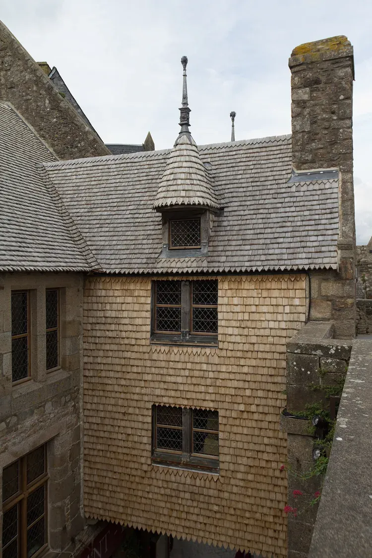 The wood-shingled roof and artichoke-shaped finial of the Maison de l'Artichaut, seen from the ramparts above Le Mont-Saint-Michel