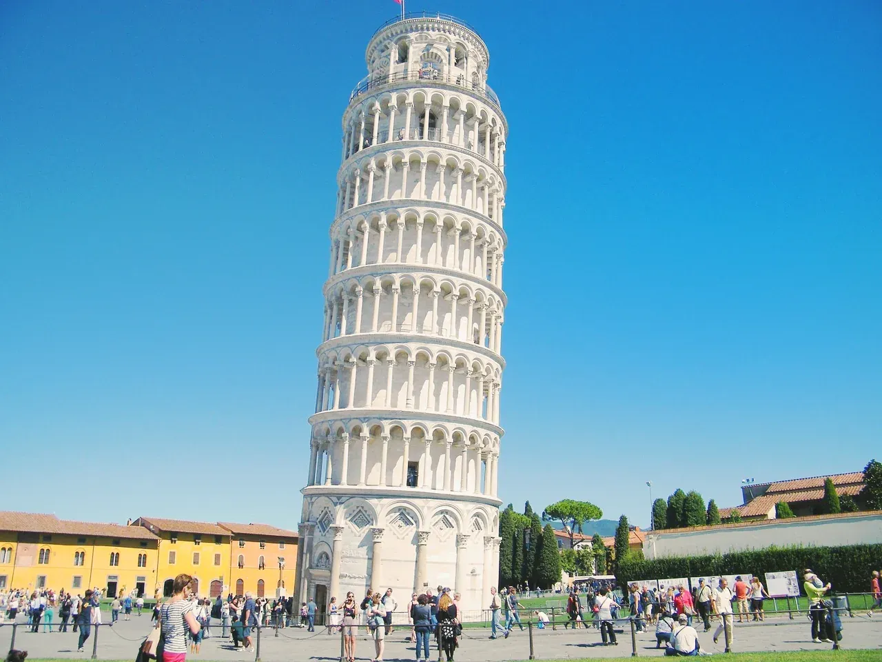 The Leaning Tower of Pisa rising above visitors in the Piazza dei Miracoli