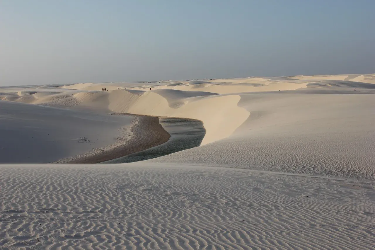 A lagoon lying between white dunes in Lencois Maranhenses