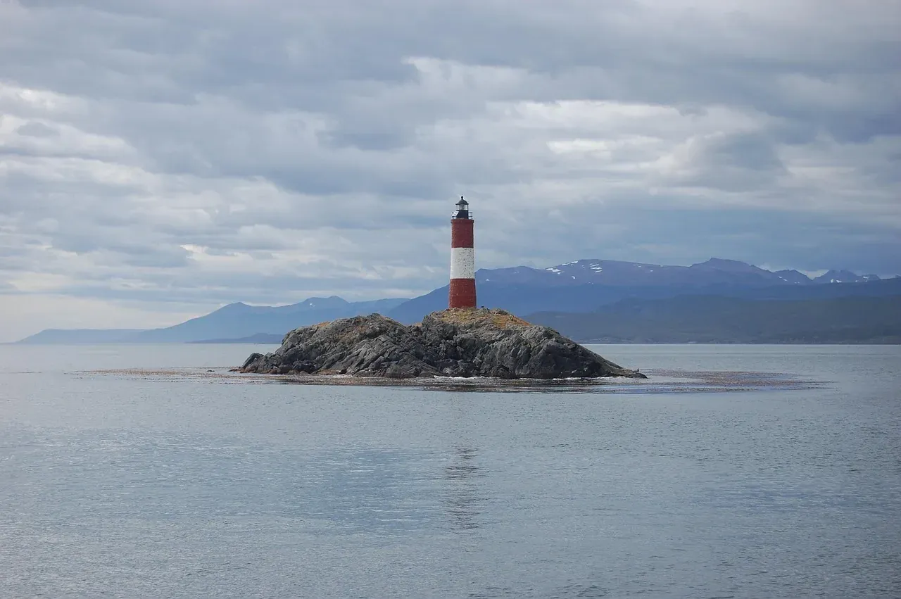 The red and white Les Éclaireurs lighthouse on its islet in the Beagle Channel off Ushuaia