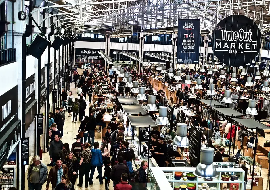 The iron-roofed hall of Time Out Market in Lisbon, seen from above with food stalls and seating below