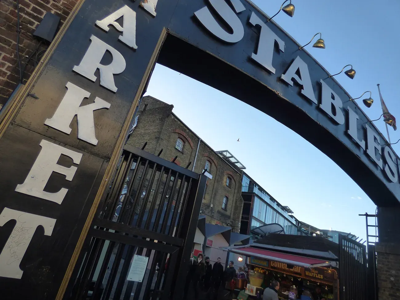 The Stables Market entrance arch in Camden, London, with Victorian brick buildings behind