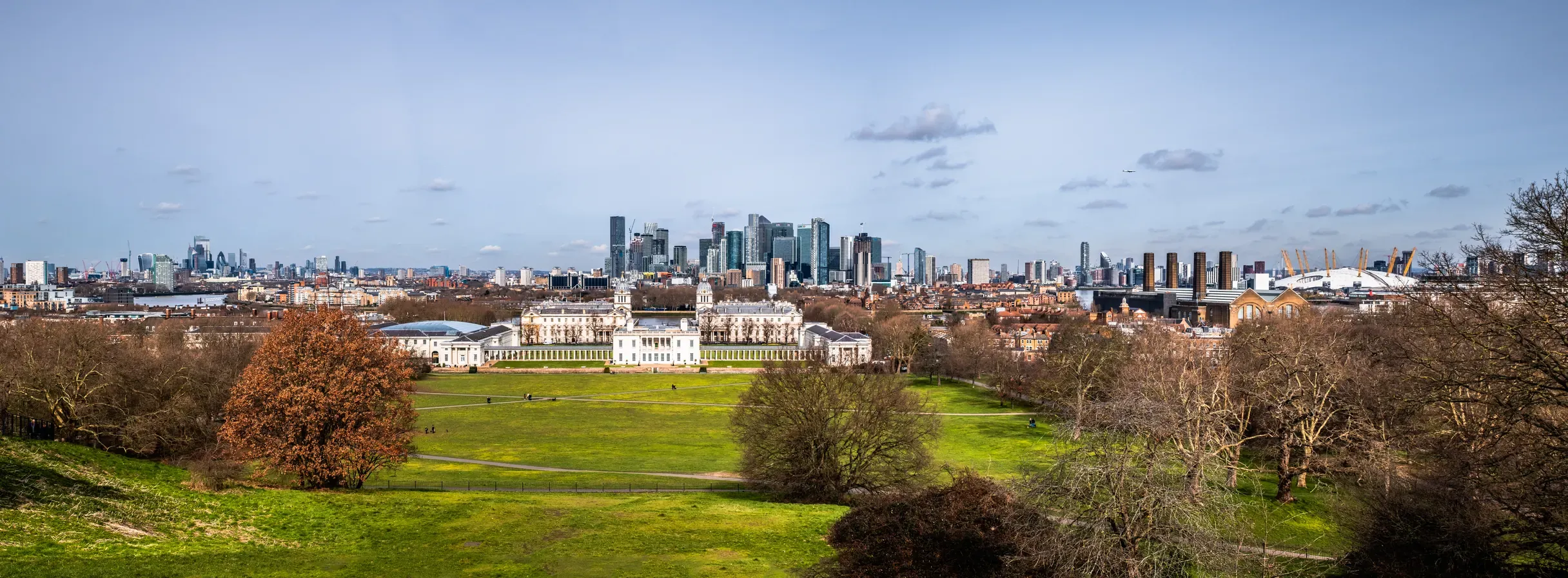 View of the London skyline from the hill in Greenwich Park, with the Queen's House, Canary Wharf and the City towers