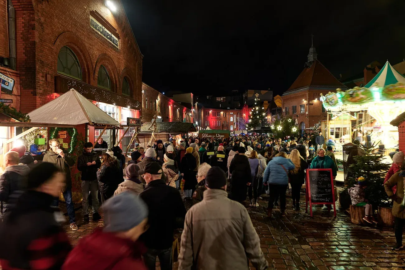 The brick courtyards of the Kulturbrauerei filled with the Lucia Christmas market at night, Berlin