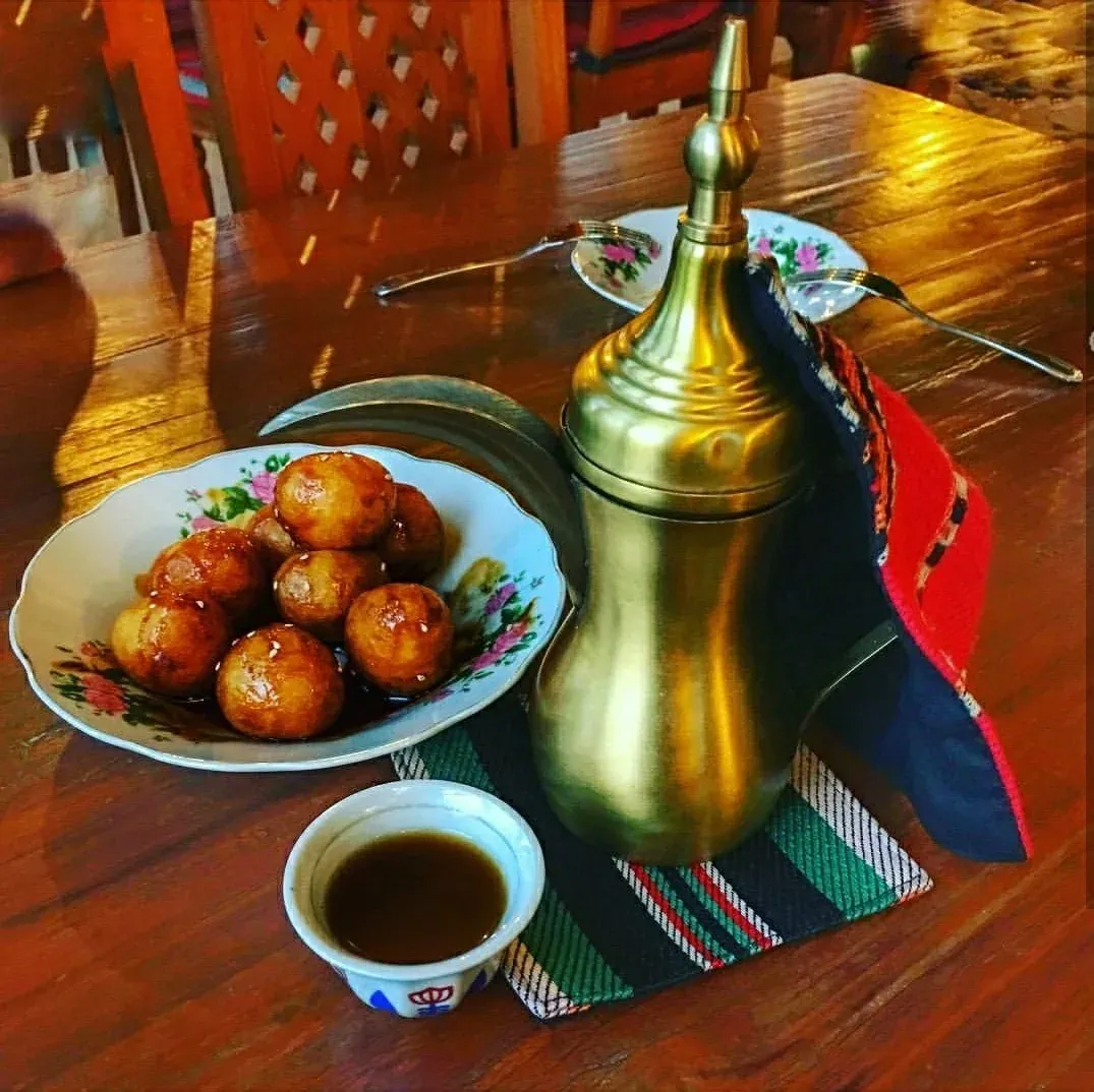 Fried luqaimat dumplings served beside a coffee pot