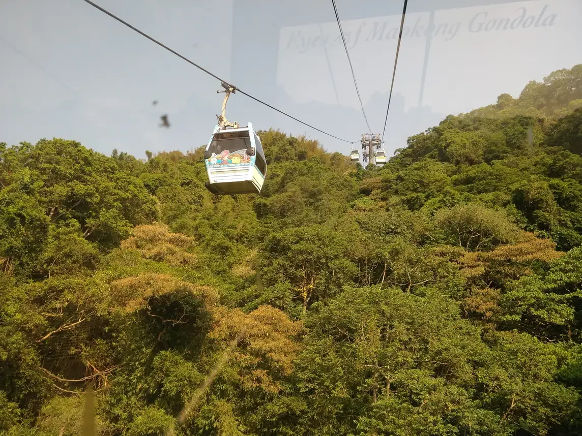 A Maokong Gondola cabin passing over forested hills, Taipei
