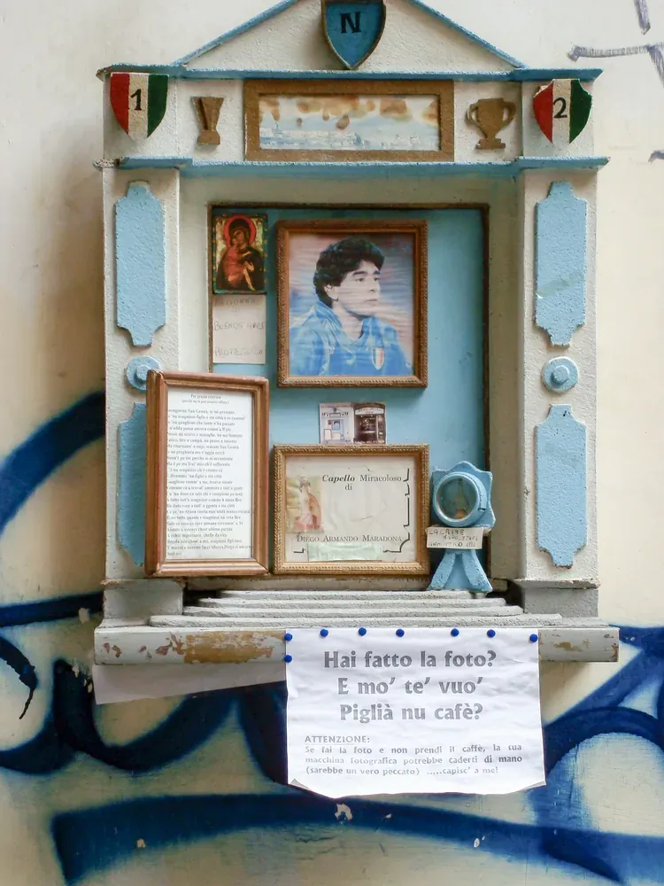 Wall shrine to Diego Maradona with a framed lock of hair on Largo Corpo di Napoli in Naples