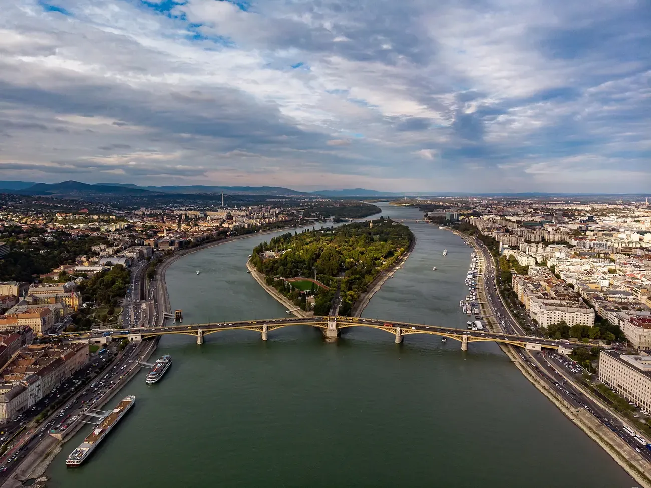 Aerial view of green Margaret Island in the Danube with the Margaret Bridge crossing the river in Budapest
