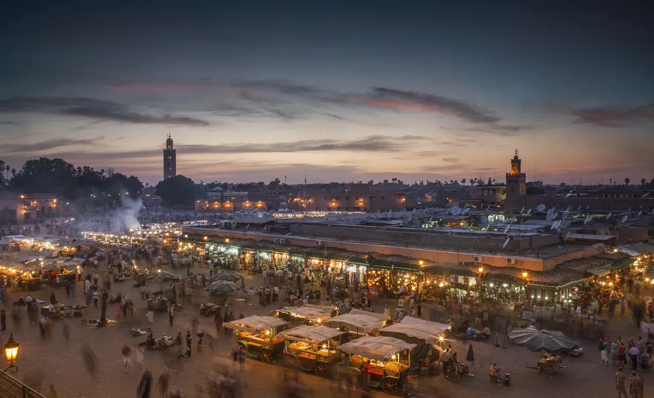 Lit food stalls and crowds spread across Jemaa el-Fnaa square in Marrakech