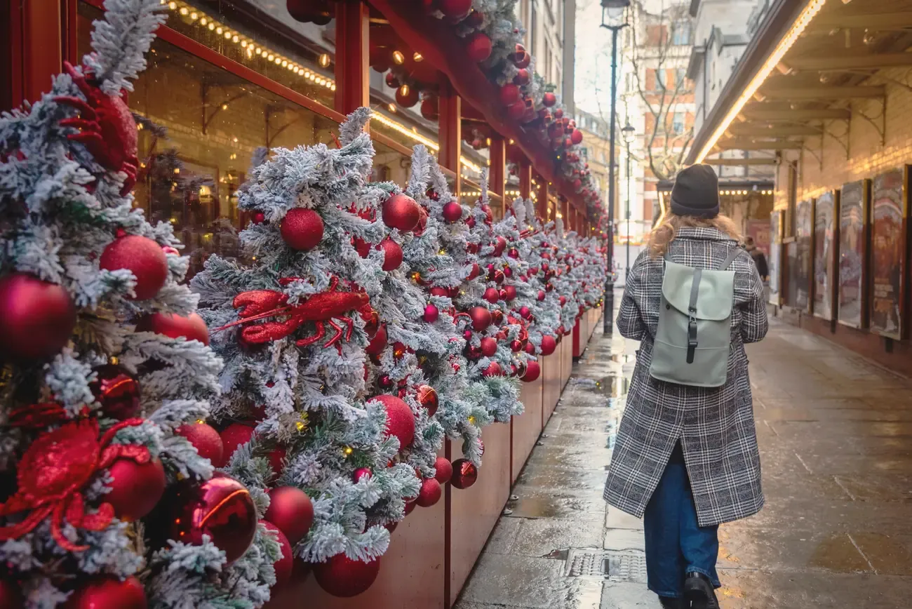 Frosted Christmas garlands with red baubles and lobster decorations along Mayfair Place, London