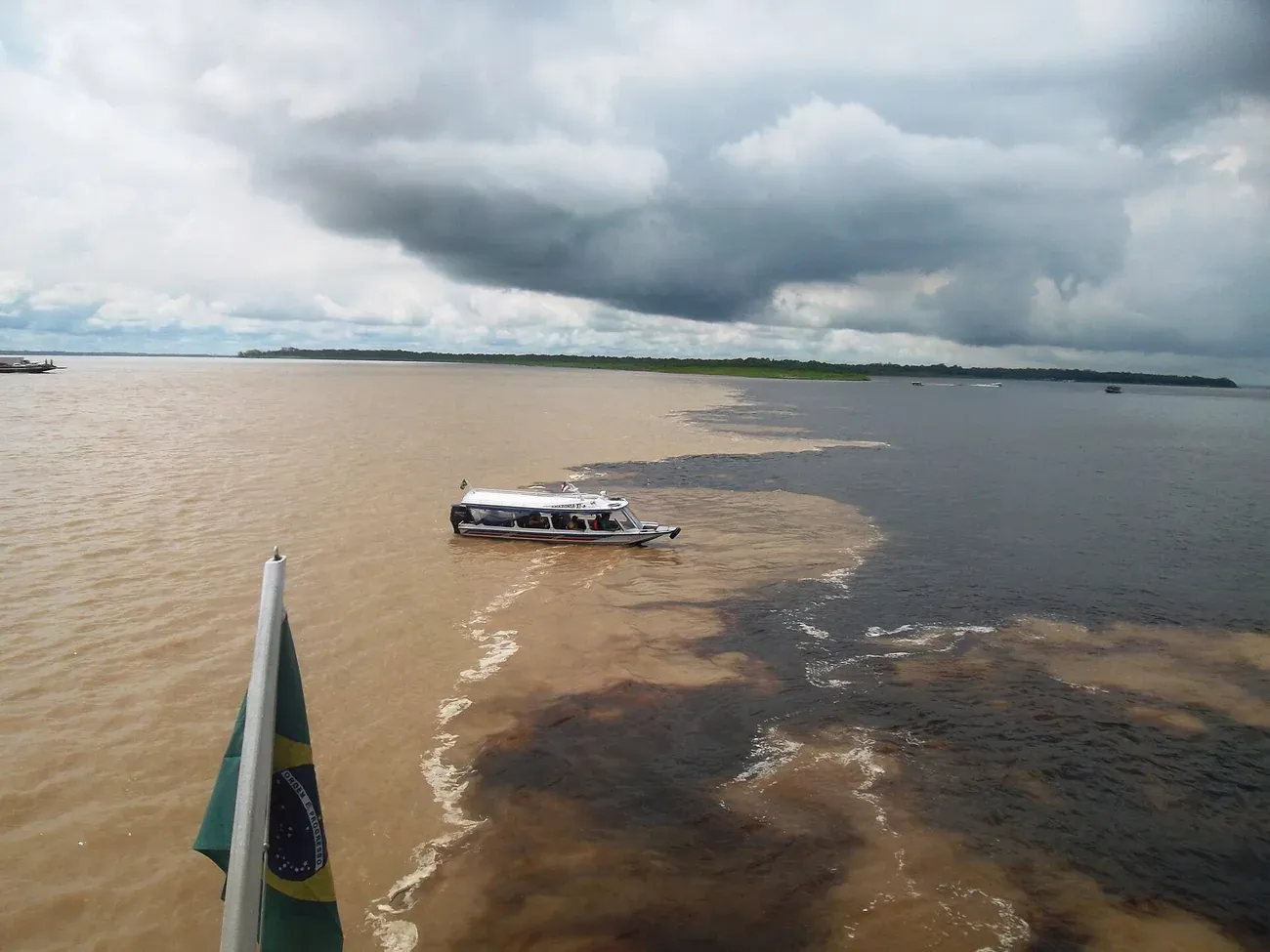 The dark Rio Negro running beside the sandy Solimoes near Manaus