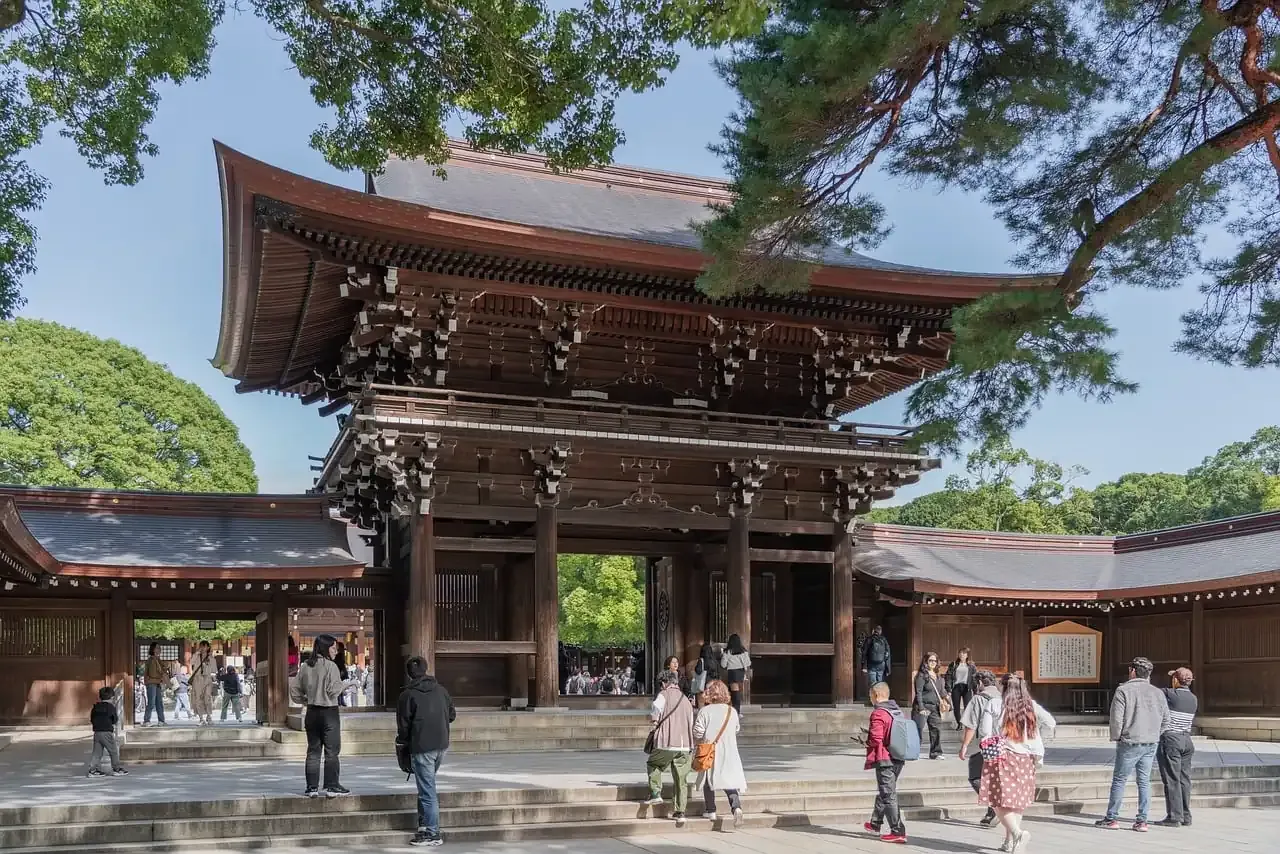 The wooden main gate of Meiji Jingu with visitors in the forecourt, Tokyo