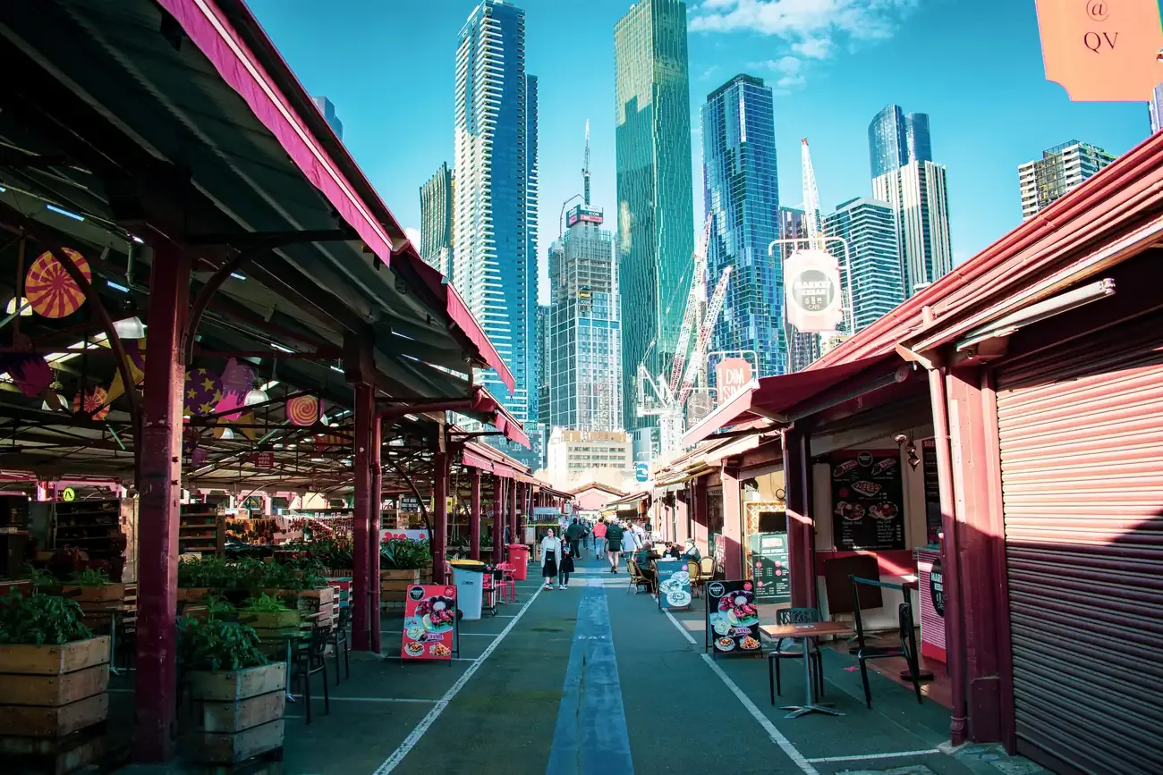 The open-air sheds of the Queen Victoria Market with the Melbourne skyline behind