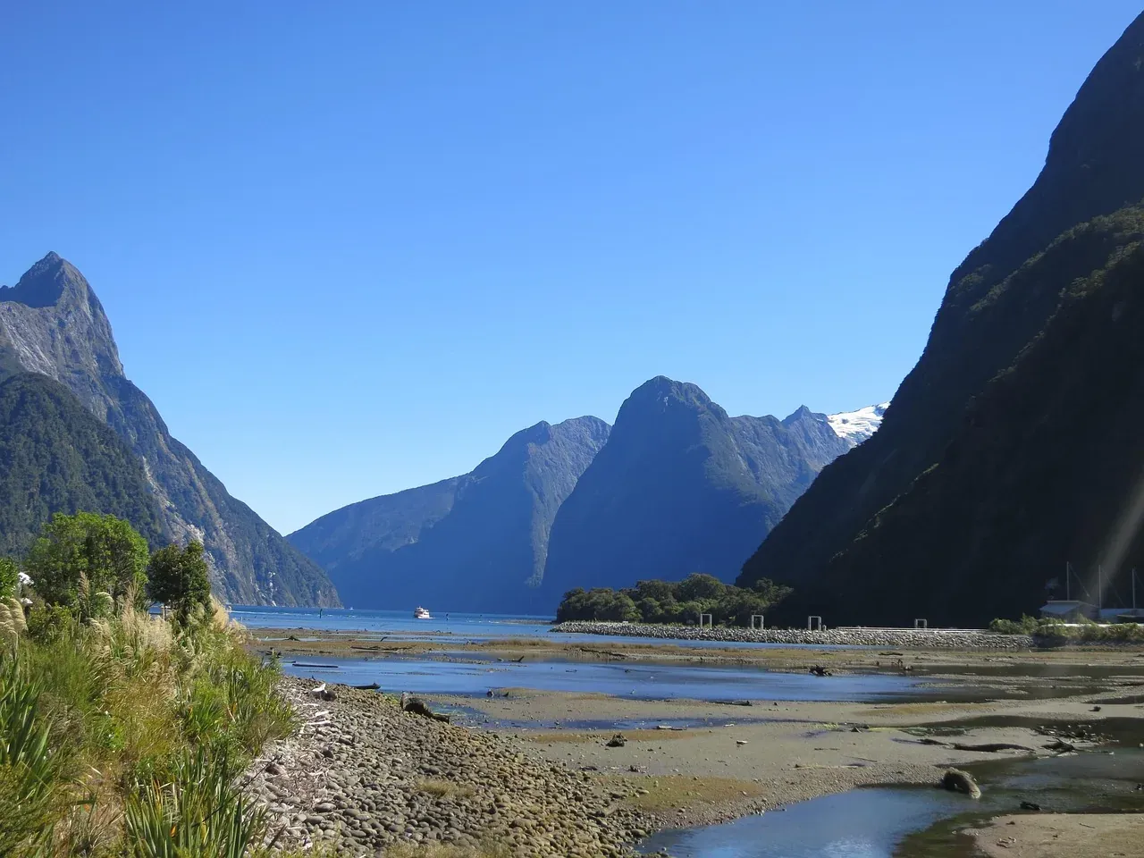The shoreline of Milford Sound with Mitre Peak at low tide