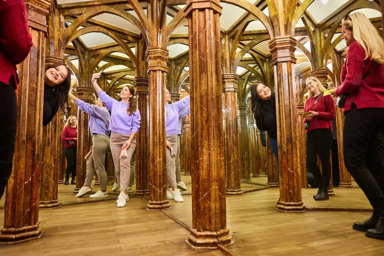 Visitors laughing inside the mirror maze on Petrin hill in Prague
