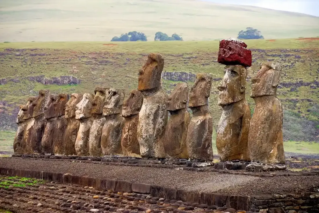 A row of moai wearing red pukao topknots on Easter Island