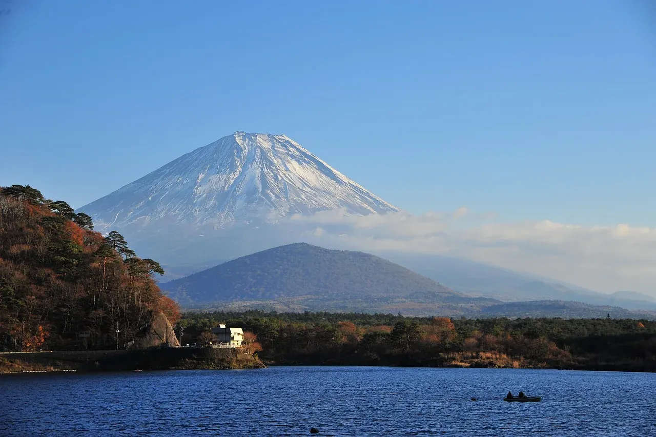 Mount Fuji rising beyond a lake in autumn in Yamanashi prefecture