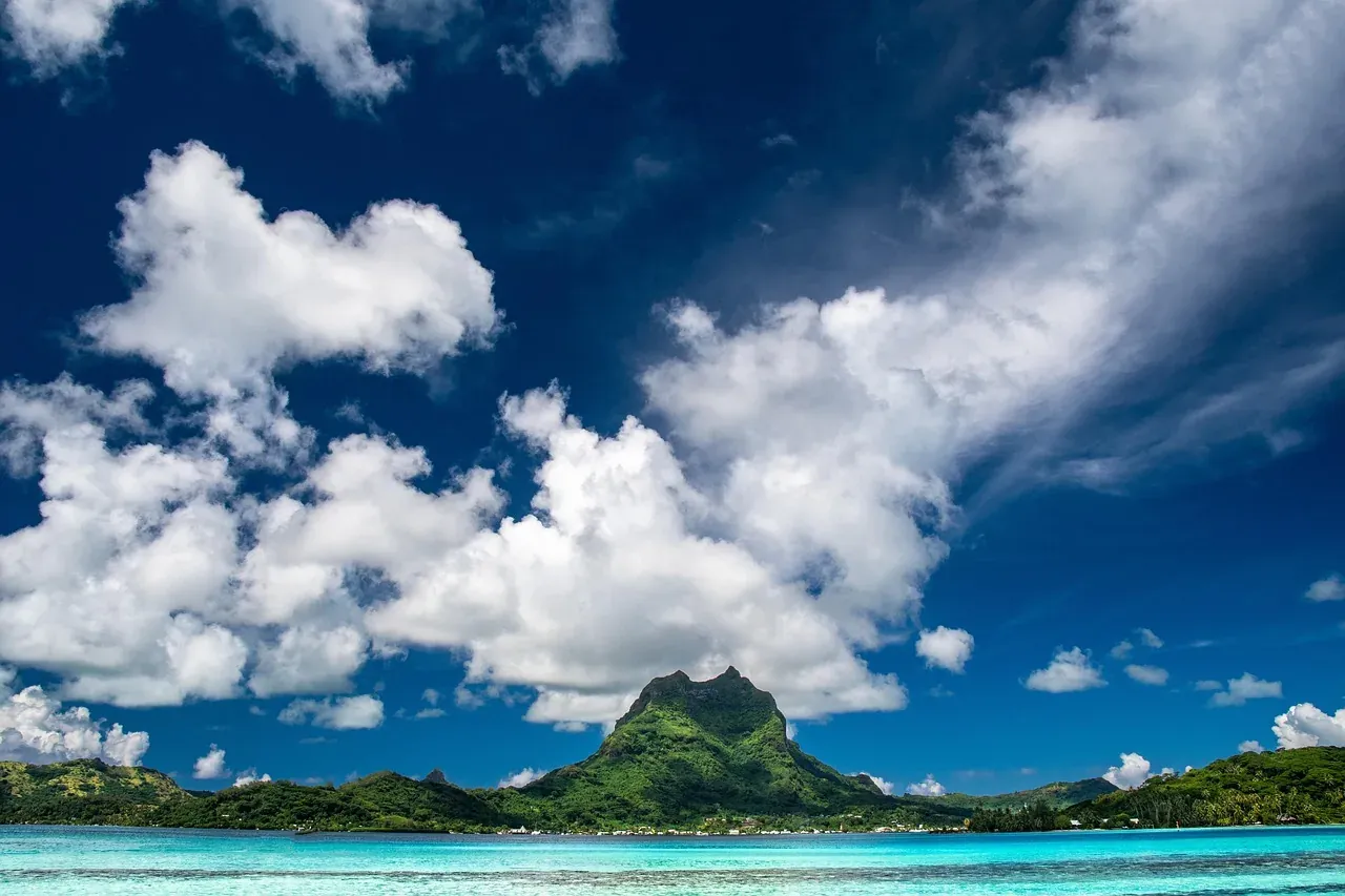 Mount Otemanu across the lagoon of Bora Bora under cumulus clouds