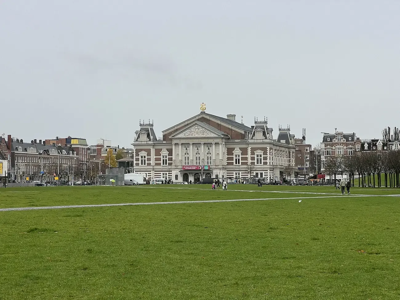 The lawn of the Museumplein in Amsterdam on an overcast day, with the Concertgebouw at the far end
