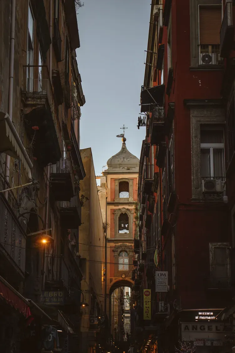 The bell tower of San Gregorio Armeno rising over the narrow street in Naples