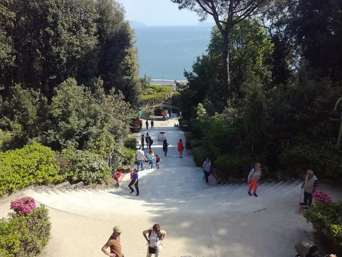 Visitors on the garden stairway of Villa Floridiana in the Vomero district of Naples, with the bay visible beyond the trees
