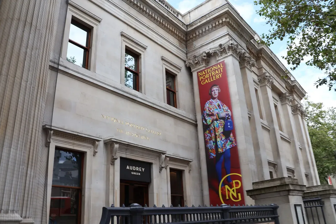 The stone front of the National Portrait Gallery in London with its banner by the entrance