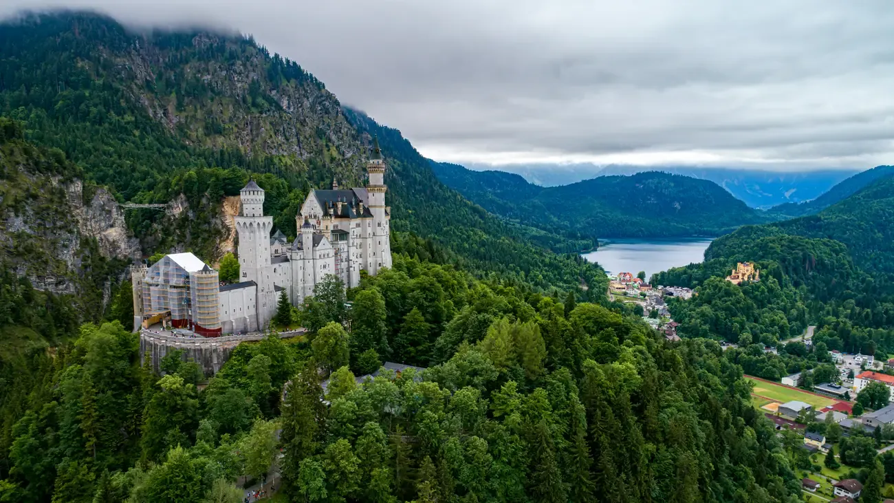 Aerial view of Neuschwanstein Castle with a lake and Hohenschwangau Castle in the distance
