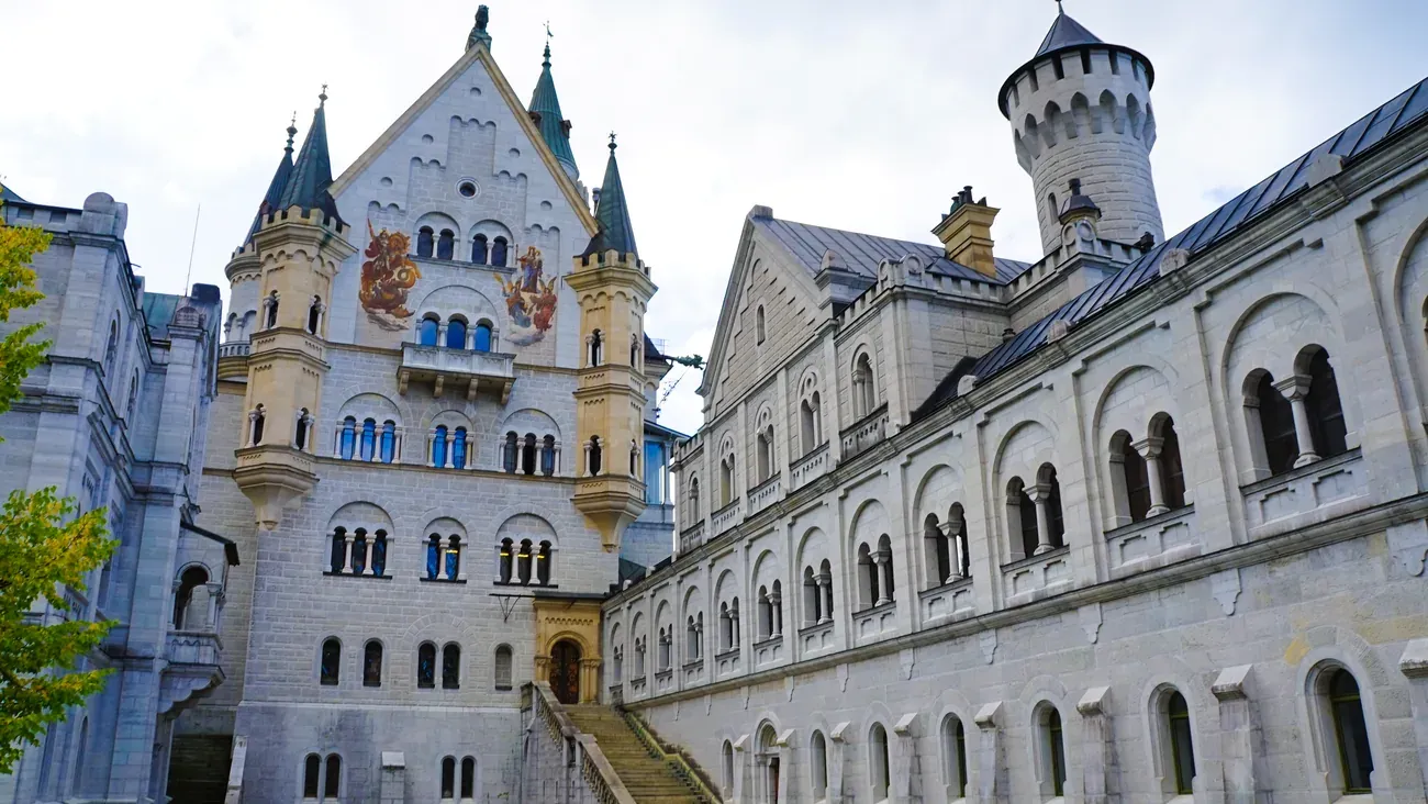 Neuschwanstein Castle's inner courtyard with painted murals and staircase