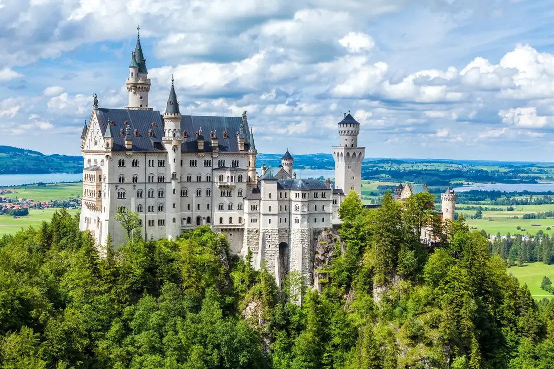 Neuschwanstein Castle on a clear summer day with a lake in the background