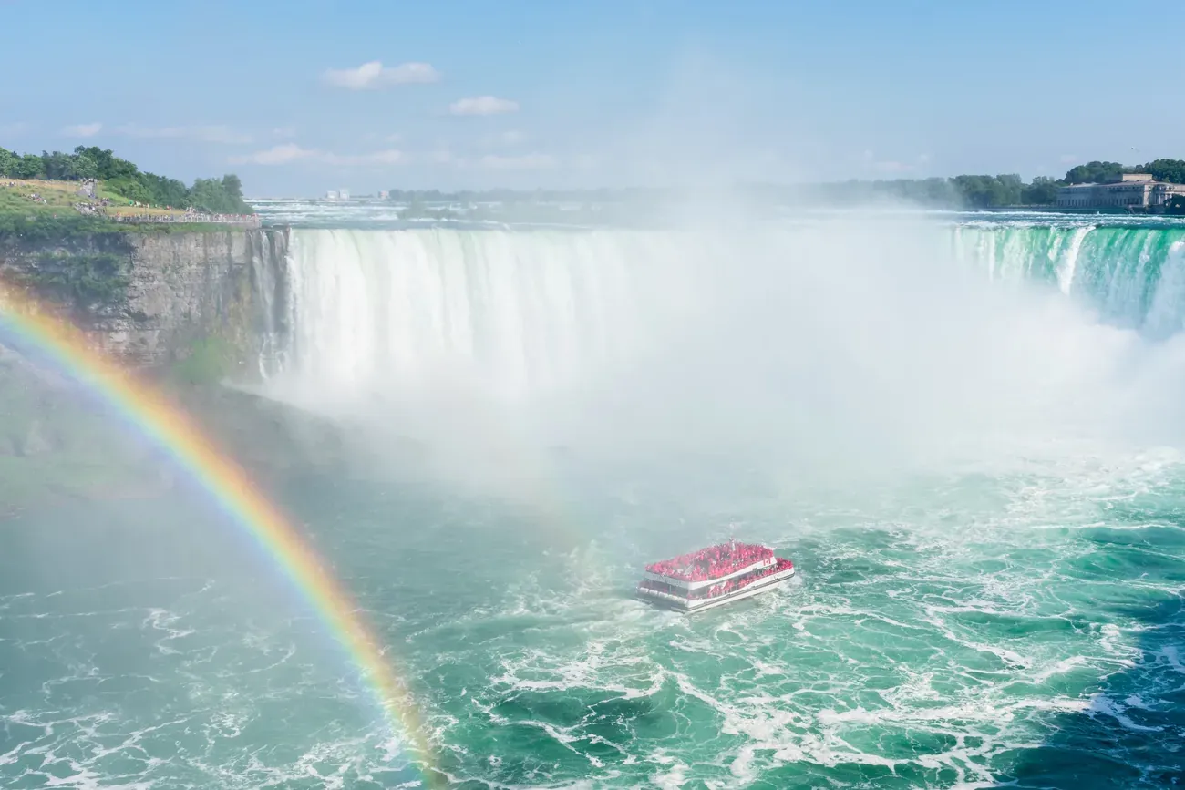 Double rainbow over Niagara Falls with a tour boat approaching Horseshoe Falls