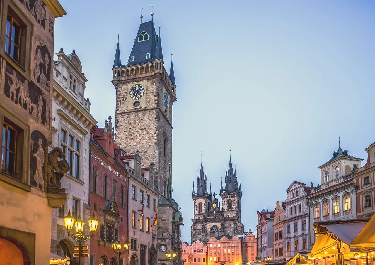 Old Town Square in Prague at dusk with the Old Town Hall tower lit