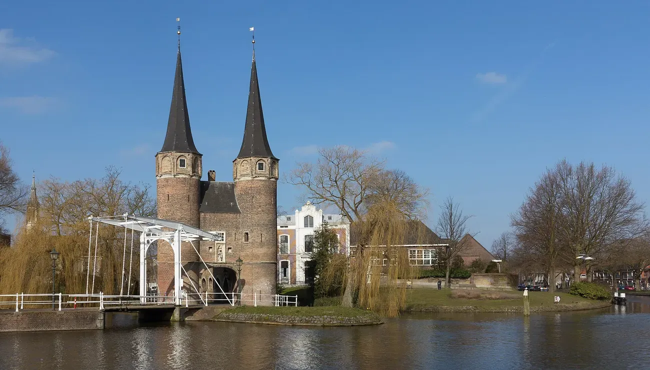 The twin brick towers of the Oostpoort city gate reflected in the canal at Delft