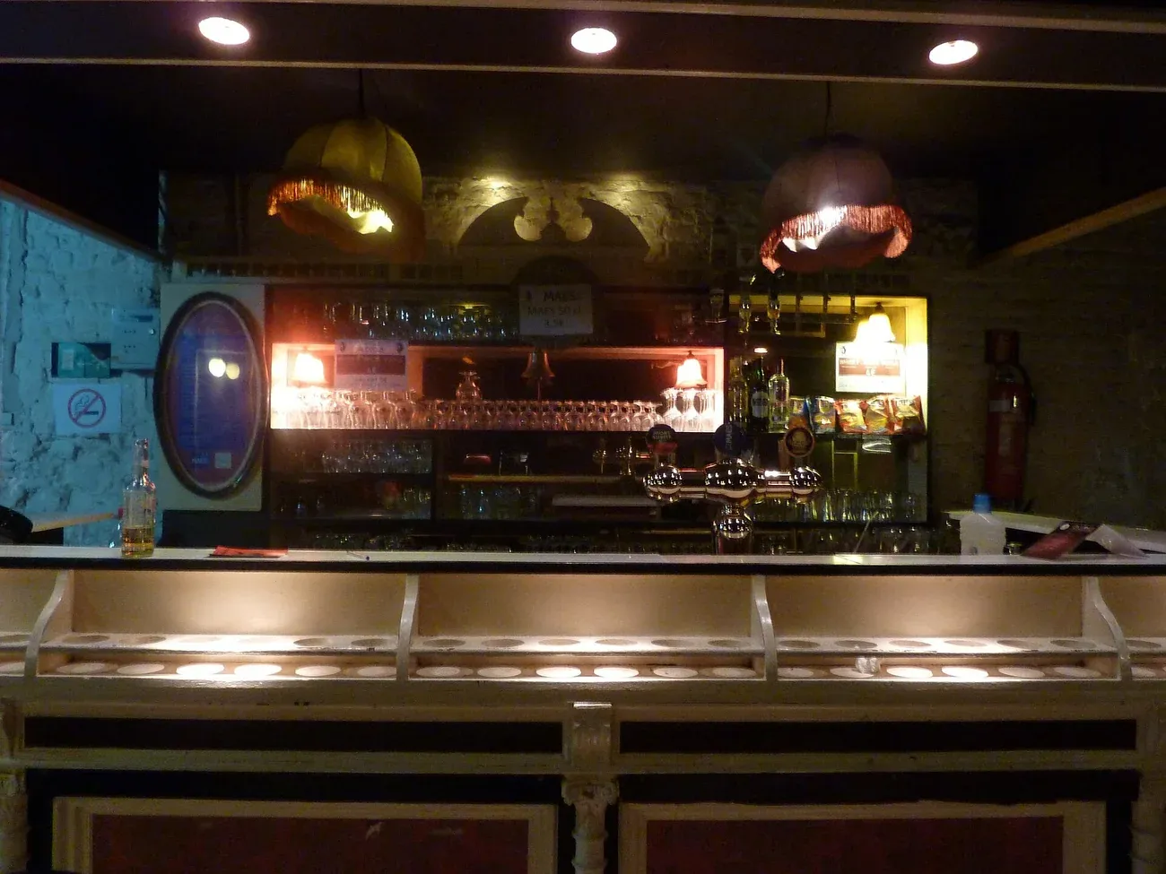 The bar of L'Os à Moelle cabaret in Schaerbeek, with warm lamps over the counter