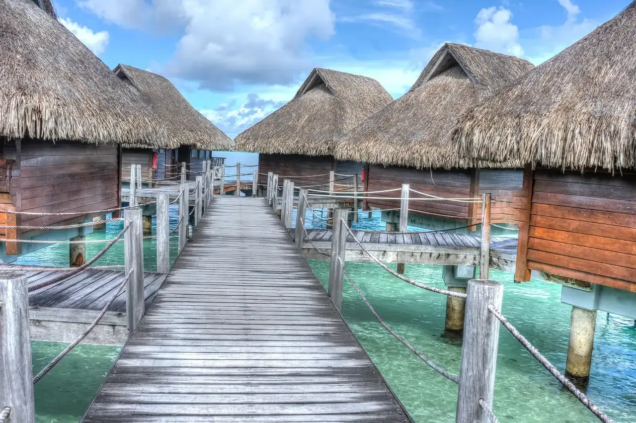 A wooden walkway between overwater bungalows on the lagoon of Bora Bora