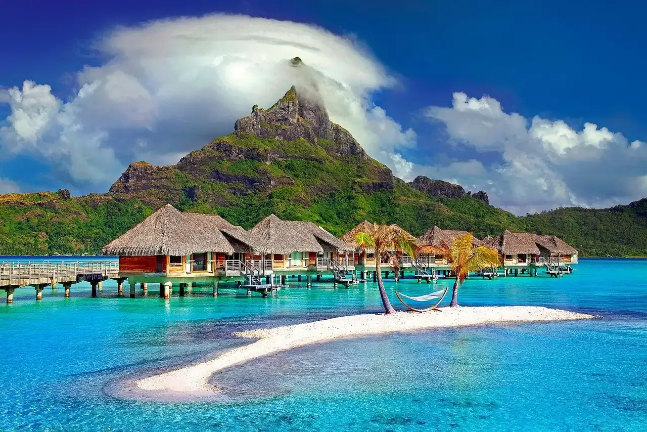 Overwater bungalows on the lagoon below Mount Otemanu in Bora Bora