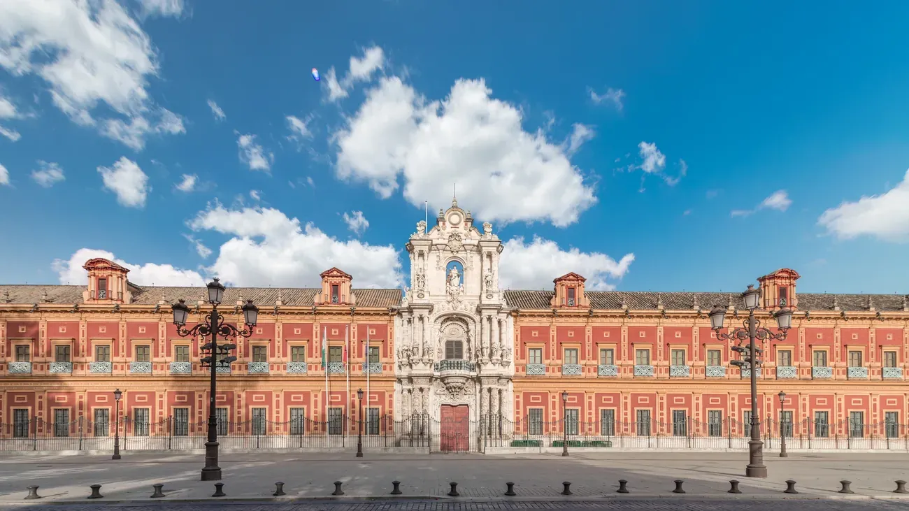 The baroque pink facade of the Palacio de San Telmo, Seville