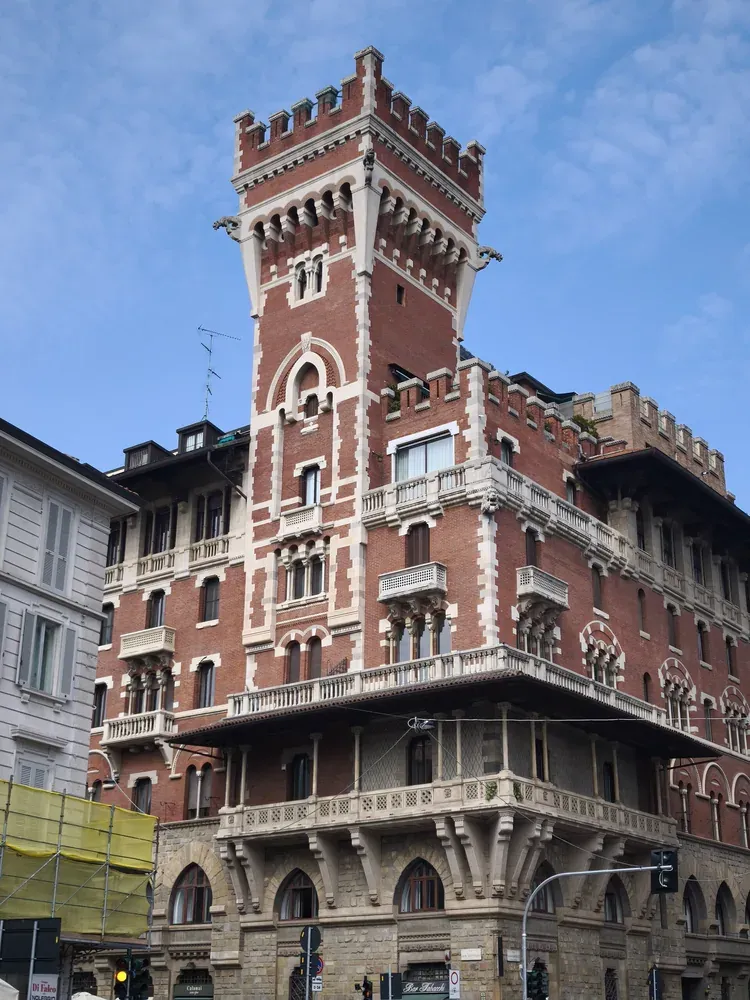 Red brick facade and crenellated tower of Palazzo Berri-Meregalli on Via Cappuccini in Milan
