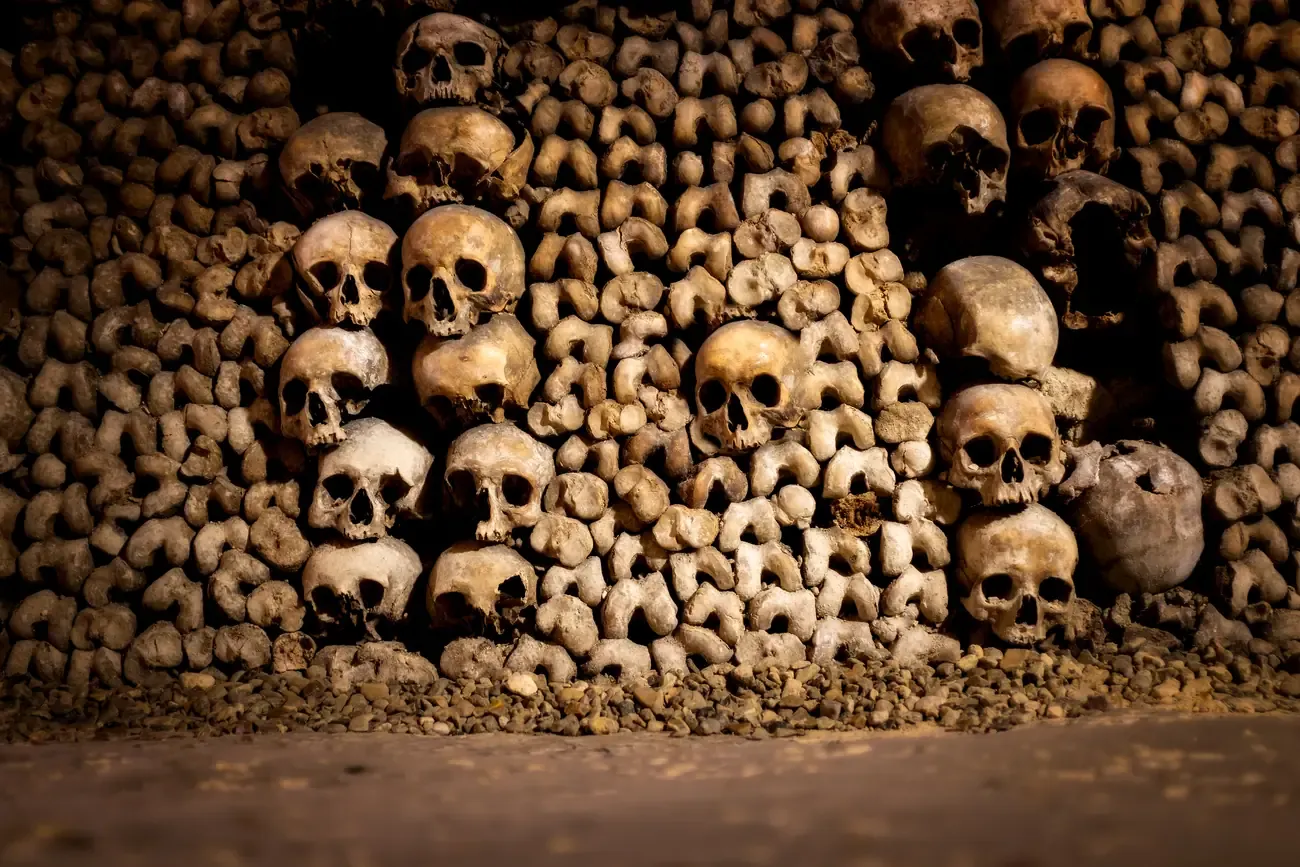 Walls of stacked human skulls and bones in the Catacombs of Paris