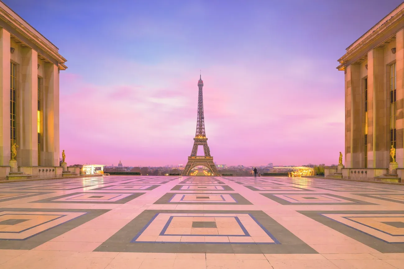 Eiffel Tower seen from the Trocadero esplanade in Paris under a pink and violet sky