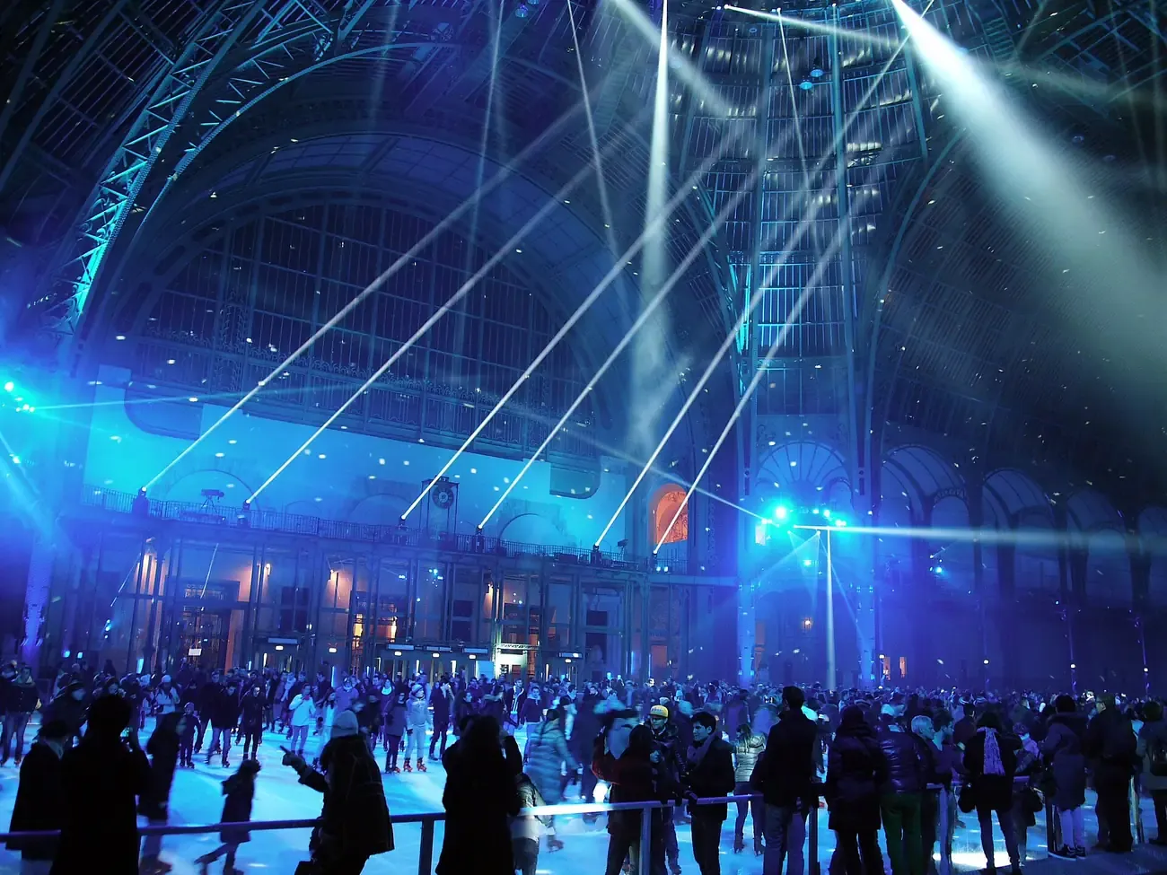 Skaters on the ice rink under the glass roof of the Grand Palais in Paris