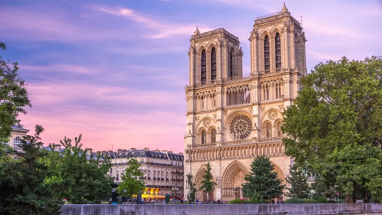 The front facade of Notre-Dame de Paris cathedral illuminated at dusk