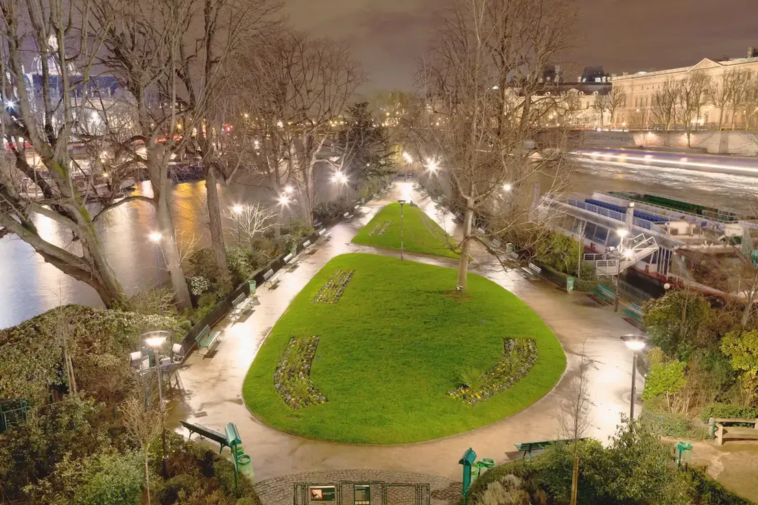 Square du Vert-Galant at the tip of the Ile de la Cite in Paris at night, with the Seine on both sides