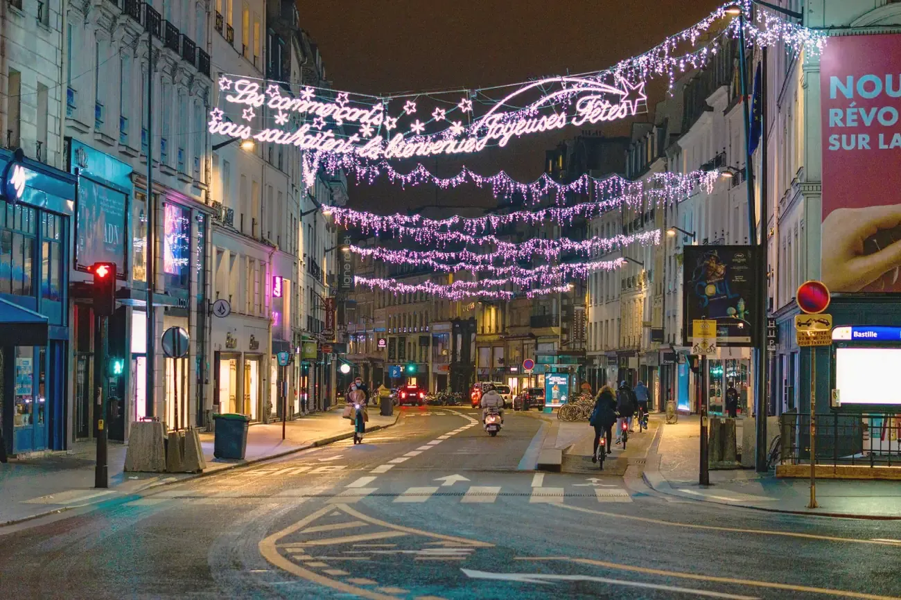 Christmas lights hanging over a street in Paris at night