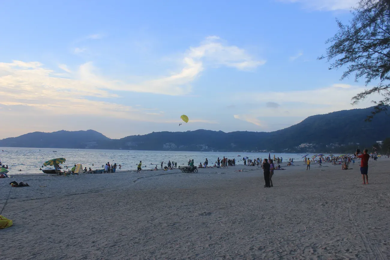 Parasailing over Patong Beach bay at dusk, Phuket