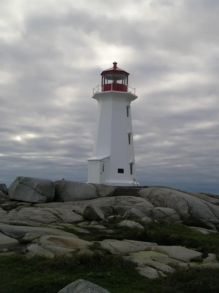 The red and white lighthouse above the granite boulders at Peggys Cove